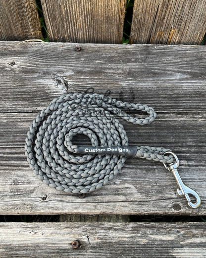 Gray braided leash with brass snap on a wooden surface