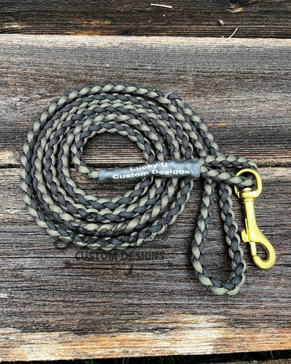 Dog leash with a brass clip on a wooden surface, branded 'Lucky You Custom Designs'.